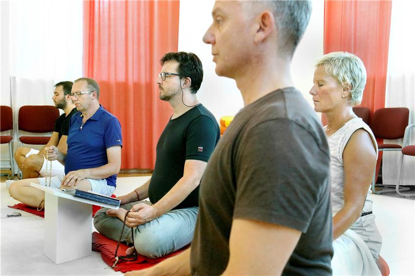 Die Meditation soll den Geist leeren, störende Gedanken werden verbannt. Stephan Böhme (Mitte) führt durch die einzelnen Phasen. Bild: Haas