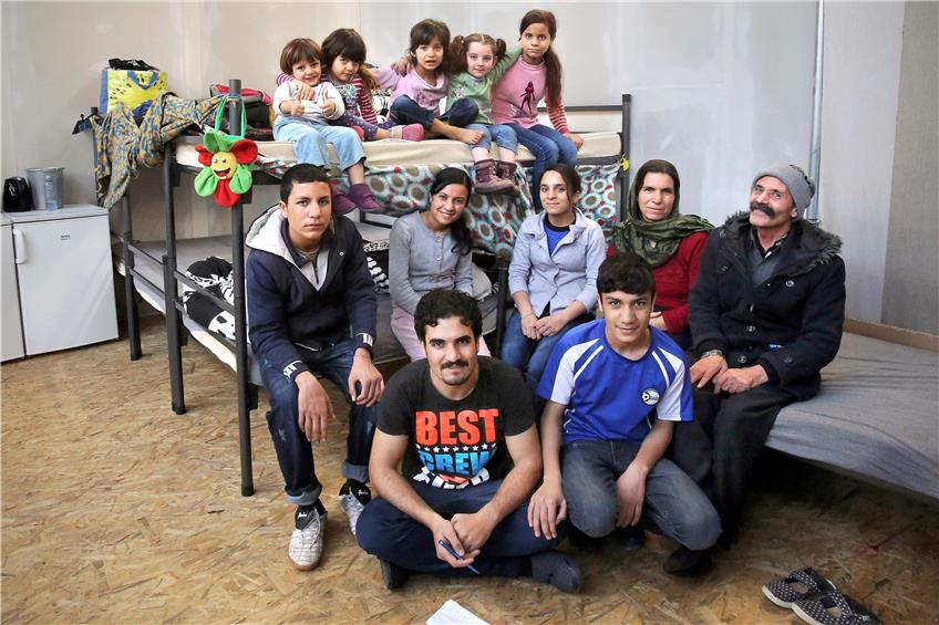 Die jesidische Großfamilie Khdida aus dem Irak in ihrer Unterkunft in der Shedhalle. Oben auf dem Etagenbett sitzen (von links) Senin (drei Jahre), Solin (vier) , Jenneifr (sechs), Khola (zwei) und Nadima (elf). Unten auf dem Bett Kamel (16), Zaitron (24), Zahra (10), Goge Mirza (Mutter) und Mejo Khdida (Vater). Auf dem Boden Khairi (22) und Karim (15). Bild: Sommer
