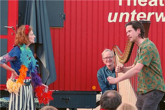 Dietlinde Elsässer (links), Hans Förster (hinten an der Harfe) und Überraschungsgast Jakob Nacken entwickeln eine neue Dorfhymne auf Dettenhausen. Bild: Stephan Gokeler