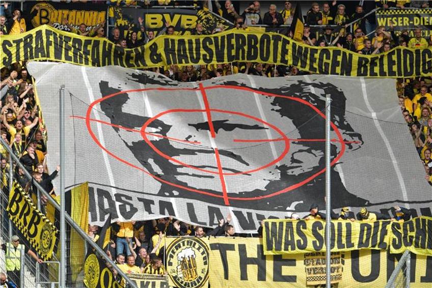 Dortmunder Fans halten zu Spielbeginn ein Transparent mit dem Konterfei von Hoffenheims Mäzen Dietmar Hopp in die Höhe. Foto: Uwe Anspach/Archiv dpa