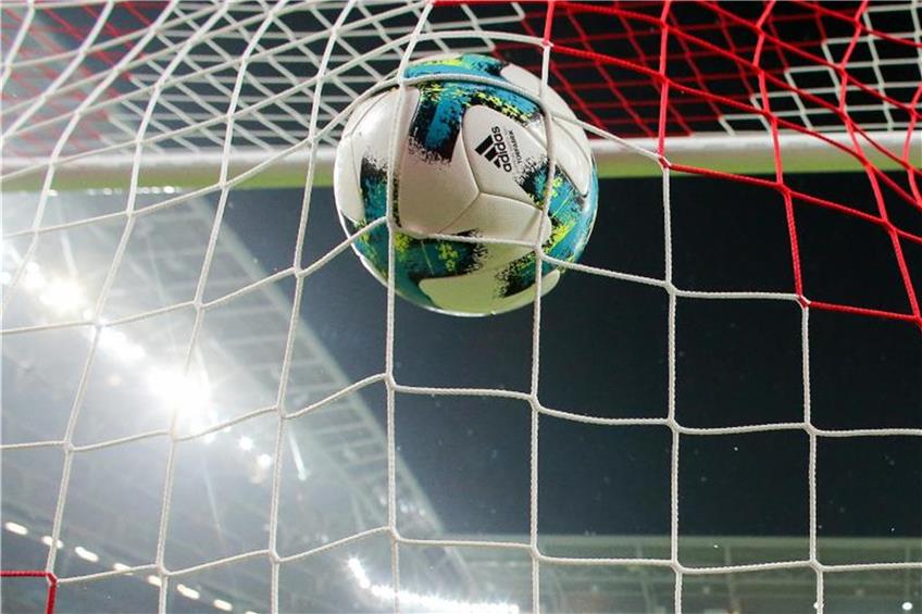 Ein Fußball fliegt ins Netz. Foto: Jan Woitas/zb/dpa/Symbolbild
