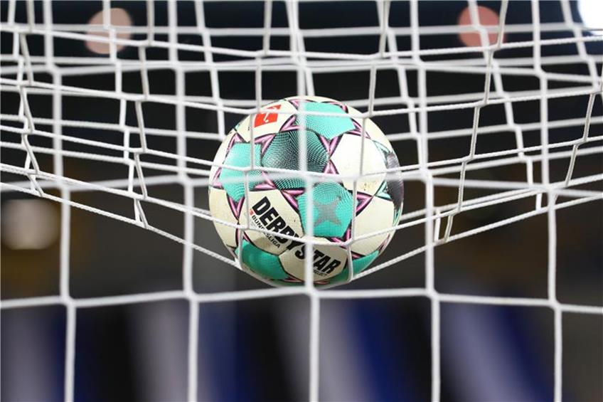 Ein Fußball liegt vor der Partie im Netz. Foto: Friso Gentsch/dpa/Symbolbild