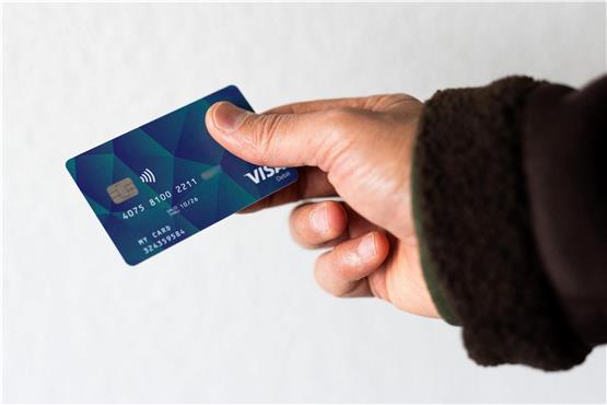 Ein Geflüchteter hält eine Debitkarte in der Hand. Foto: Philipp von Ditfurth/dpa