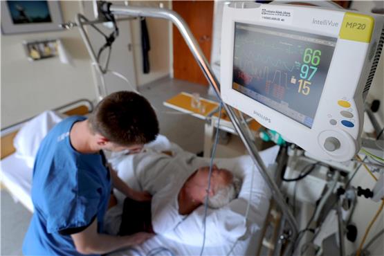 Ein Gesundheits- und Krankenpfleger überprüft in einer Klinik die Messinstrumente bei einem Schlaganfallpatienten. Foto: Angelika Warmuth/dpa/Symbolbild