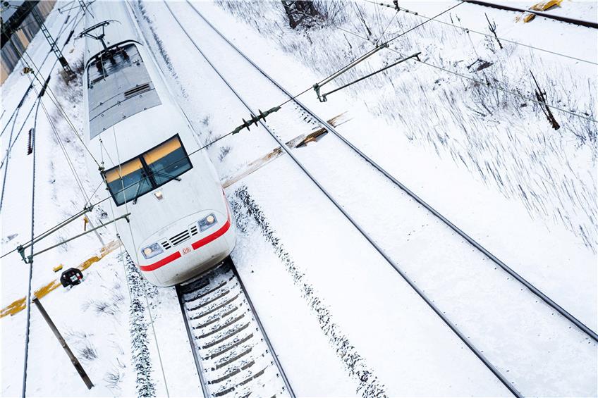 Ein ICE fährt im Bamberger Bahnhof über schneebedeckte Gleise. Foto: Nicolas Armer/dpa