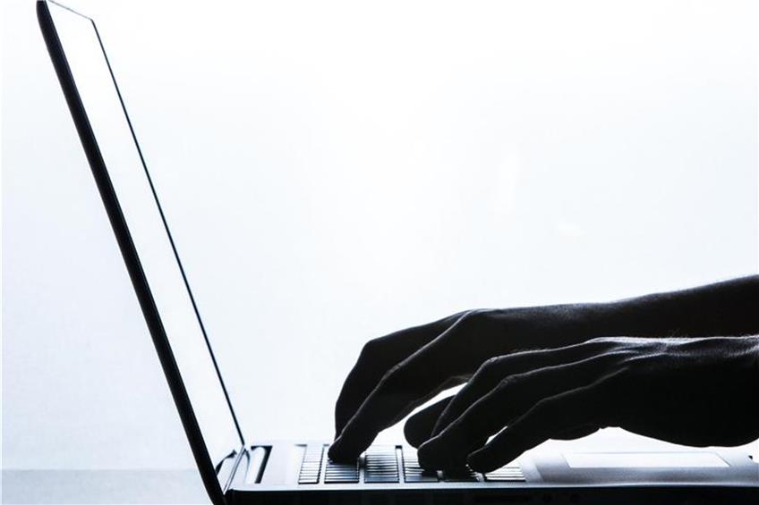 Ein Mann tippt auf einer Tastatur eines Laptops. Foto: Silas Stein/Archivbild