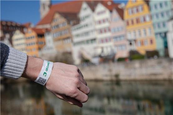 Ein Mann trägt in Tübingen ein Tagesticket-Armband. Foto: Christoph Schmidt/dpa/Archivbild
