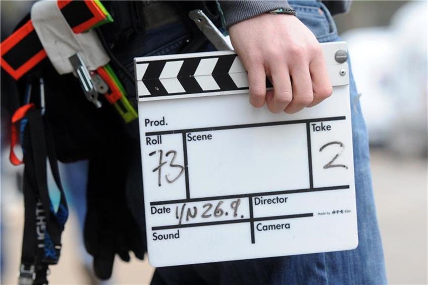 Ein Mitarbeiter eines Filmteams hält eine Filmklappe. Foto: picture alliance/dpa/Symbolbild