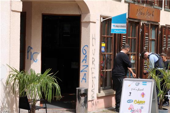 Ein Polizist (rechts) dokumentiert die Graffiti an dem Kiosk beim Metzelplatz. Daneben steht ein Mitarbeiter. Bild: Anton Bandomer