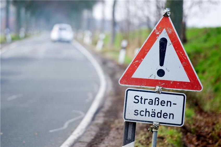 Ein Schild mit der Aufschrift „Straßenschäden“ an einer Straße. Foto: Christoph Schmidt/Archiv dpa/lsw