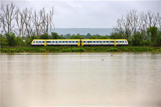 Ein Zug fährt an einer vom Regen überfluteten Wiese vorbei. Foto: dpa
