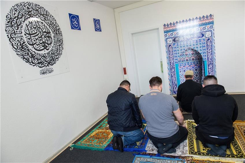 Ein muslimische Seelsorger (2.v.r.) betet mit Häftlingen in einem Gebetsraum einer Justizvollzugsanstalt. Foto: Silas Stein/dpa
