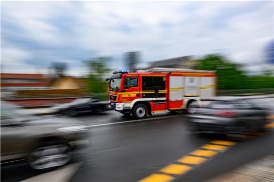 Eine Feuerwehrfahrzeug fährt mit Blaulicht zu einem Einsatz. Foto: Robert Michael/dpa
