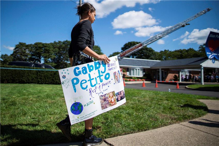 Eine Frau trägt ein Plakat zur Trauerfeier für Gabby Petito. Foto: Eduardo Munoz Avarez/AP/dpa