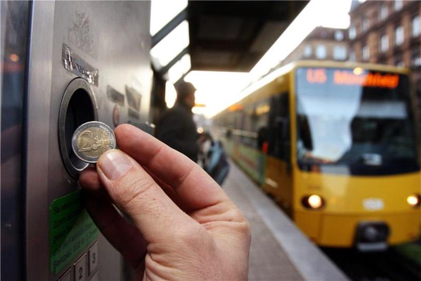 Eine Hand hält eine 2-Euro-Münze vor einem Fahrkartenautomaten. Foto: Bernd Weißbrod/Archiv dpa/lsw