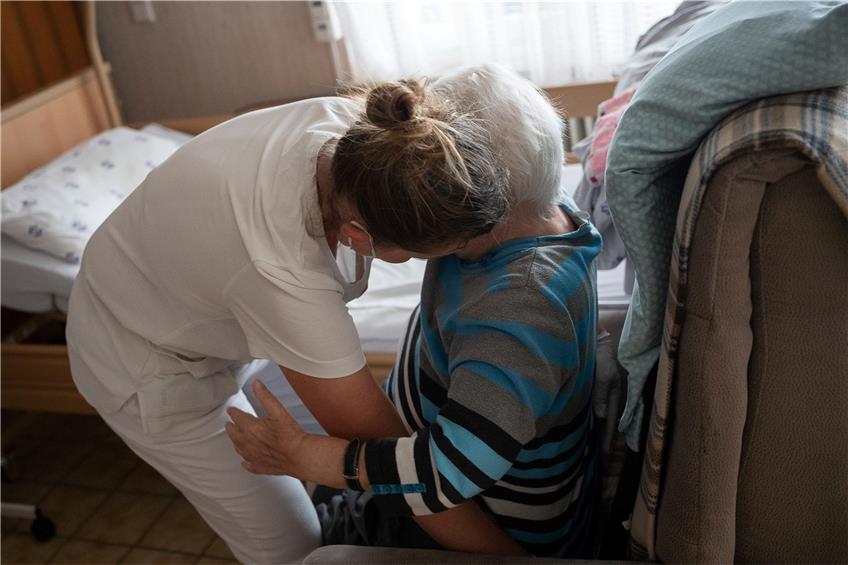 Eine Pflegefachkraft hilft in der ambulanten Pflege einer Frau beim Umsetzen. Foto: Sebastian Gollnow/dpa/Symbolbild