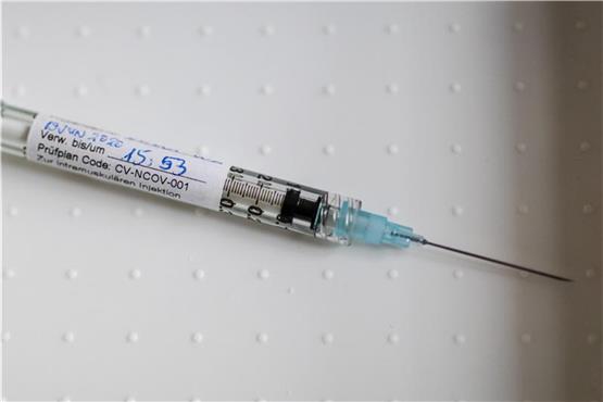Eine Spritze mit einem Impfstoff liegt auf einem Tisch. Foto: Christoph Schmidt/dpa/Symbolbild