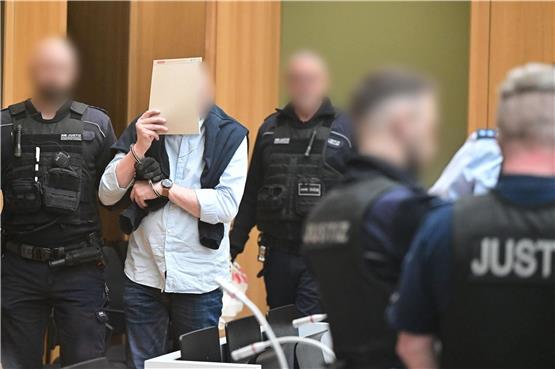 Einer der insgesamt neun Angeklagten wird in Stuttgart-Stammheim in den Gerichtssaal geführt.