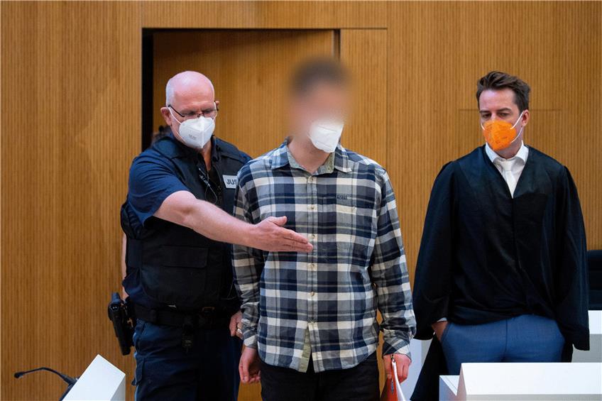 Einer der zwei wegen Mordes angeklagten Männer wird vor Beginn der Verhandlung in den Sitzungssaal geführt.  Foto: Sven Hoppe/dpa