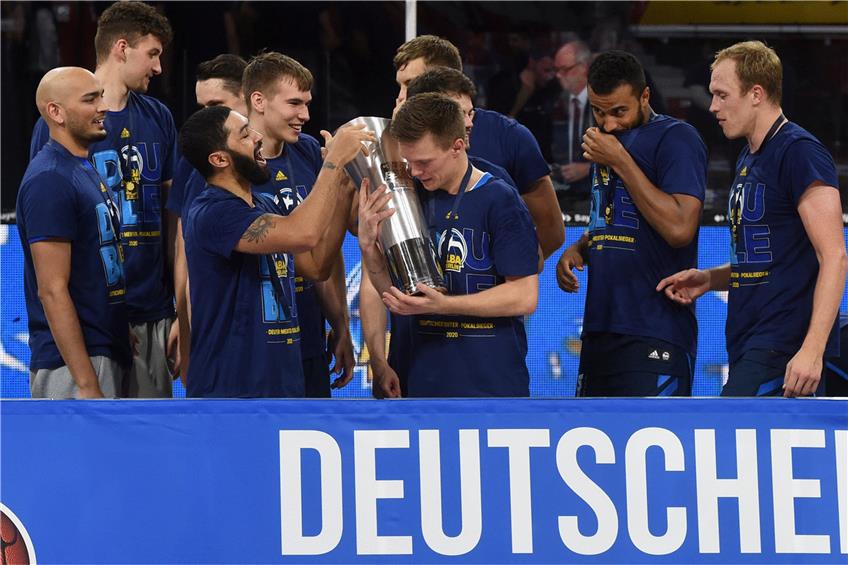 Endlich Meister! Alba Berlins Martin Hermannsson will den Pokal am liebsten gar nicht mehr hergeben. Foto: Christof Stache/dpa