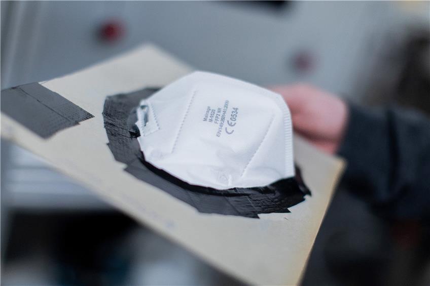 FFP2-Maske in einen Versuchsaufbau, der Partikelabscheidung überpüft. Foto: Rolf Vennenbernd/dpa
