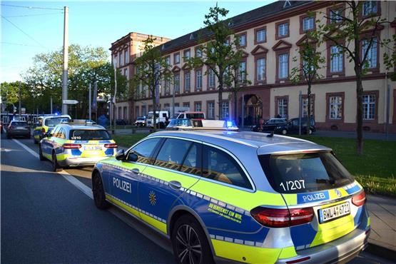 Fahrzeuge der Polizei stehen vor der Universität in Mannheim. Nach den tödlichen Schüssen auf einen mit einer Machete bewaffneten Mann in einer Mannheimer Universität laufen die Ermittlungen auf Hochtouren. Foto: René Priebe/dpa
