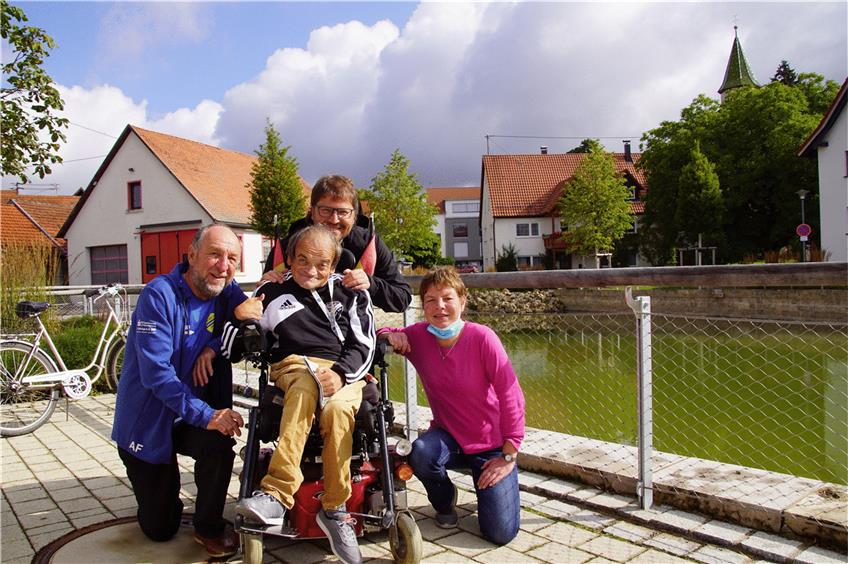 Familienmitglied für viele: Helmut Rühl ist der Dorfmittelpunkt in Blaubeuren-Asch. Arthur Fahrner, Bernd Schlumpberger und Silvia Mattheis (von links) kümmern sich um den Rollstuhlfahrer  wie viele andere im Ort. Foto: Karin Mitschang
