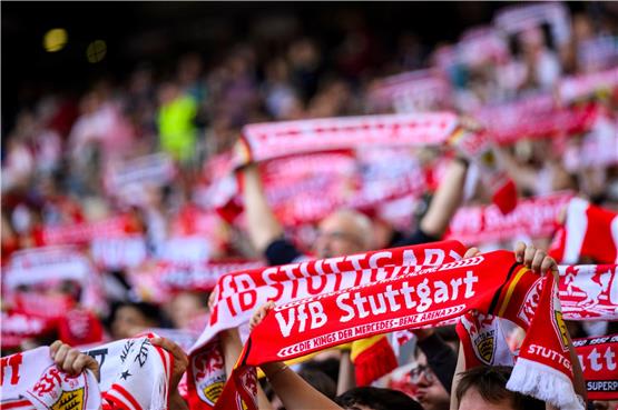 Fans des VfB Stuttgart halten Fanschals im Stadion hoch. Im Sommer fliegt der VfB für eine Woche nach Japan. Foto: Tom Weller/dpa/Archivbild