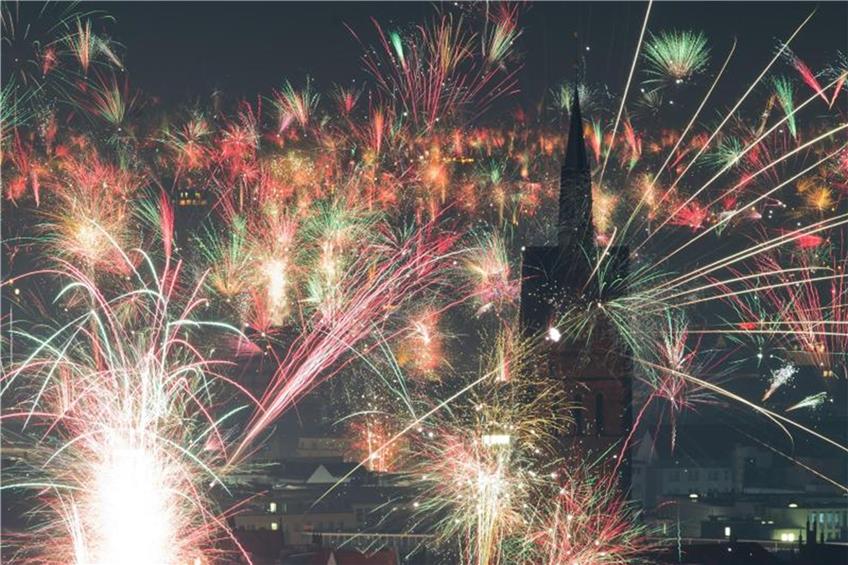 Feuerwerk explodiert kurz nach Mitternacht am Nachthimmel über der Marktkirche. Foto: Julian Stratenschulte/dpa