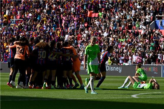 Finale verloren: Während die Barcelona-Spielerinnen feiern, trauert das Team des VfL Wolfsburg, weil die Frauen sich das 2:0 Halbzeit-Ergebnis haben abnehmen lassen und das Spiel am Ende 2:3 verloren ging. Foto: John Thys/afp