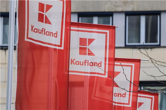 Flaggen von Kaufland hängen vor einer Filiale in Köln-Ehrenfeld. Foto: Oliver Berg/dpa/Archivbild