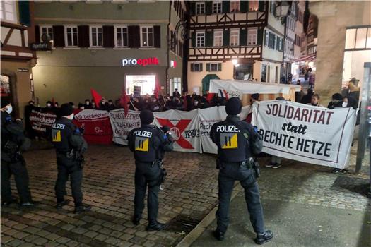 Gegendemonstranten und Polizei haben sich zwischen Tübinger Marktplatz und Holzmarkt aufgebaut. Bild: Lorenzo Zimmer