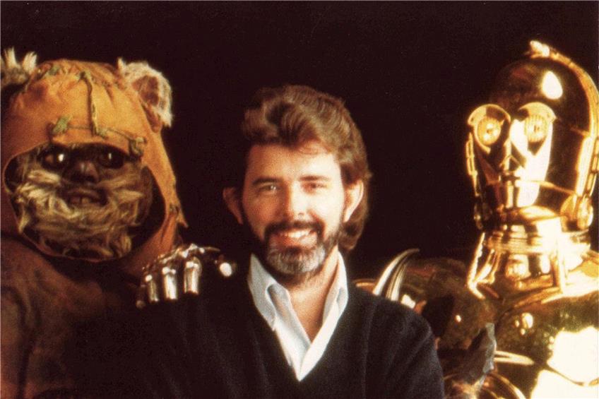 George Lucas 1983 mit den Ewoks aus „Die Rückkehr der Jedi-Ritter“ und mit C3PO. Der Star-Wars-Schöpfer war nahezu der Einzige, der die pelzigen Gesellen mochte. In einer der digitalen Nachbearbeitungen sorgte Lucas später dafür, dass die Ewoks blinzeln konnten. Foto: mauritius images/Photo 12/Alamy