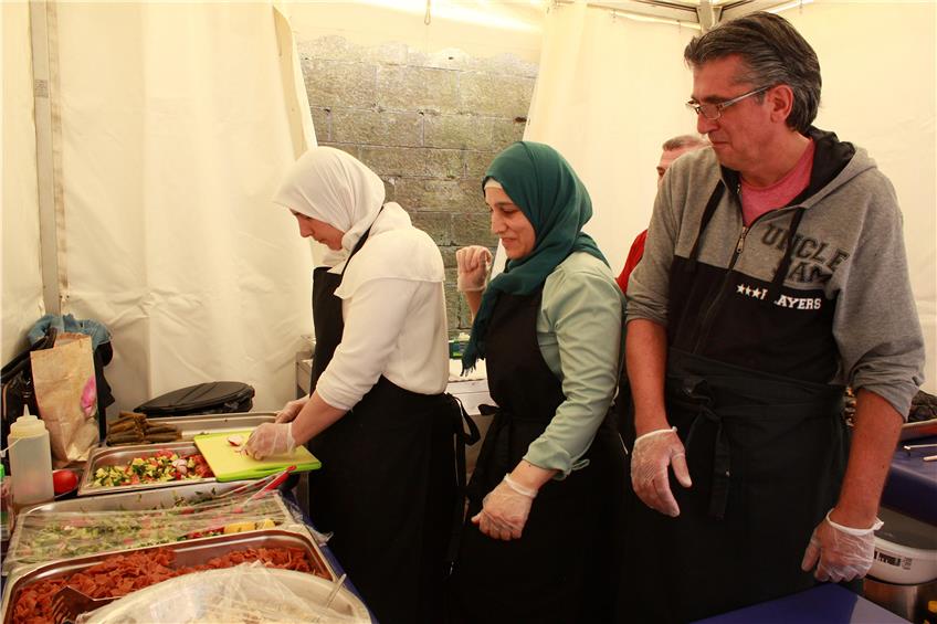 Gestern beim Streetfood-Festival: Im Pavillon der Familie Al Aksher aus dem syrischen Homs ging es eng, aber vergnügt zu. Bild: Janßen