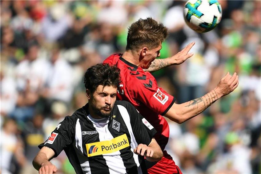 Gladbachs Tobias Strobl (l) und Freiburgs Tim Kleindienst kämpfen um den Ball. Foto: Federico Gambarini dpa