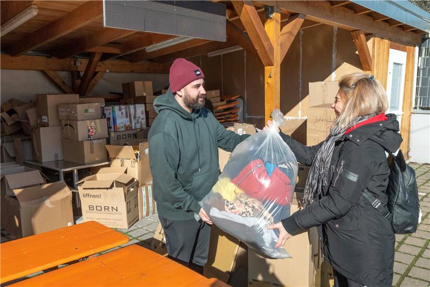 Göktug Bas von der Islamischen Vereinigung Mössingen nimmt Spenden für die Erdbebenopfer entgegen. Im Hintergrund stapeln sich die fertigen Kisten für den Transport. Bild: Klaus Franke