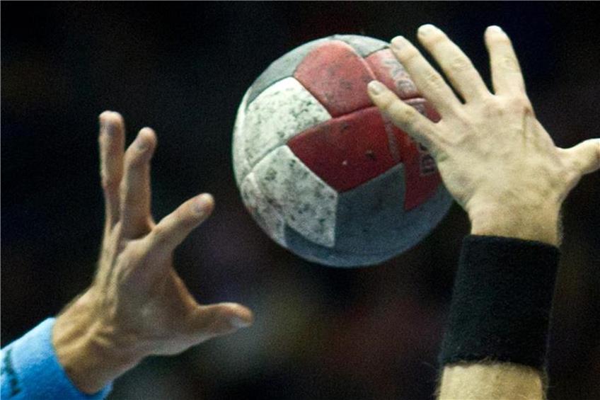 Handball-Spieler versuchen an den Ball zu kommen. Foto: Jens Wolf/Archiv dpa