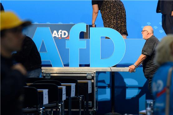Helfer schieben nach der AfD Europawahlversammlung das AfD Logo aus der Messehalle. Foto: Klaus-Dietmar Gabbert/dpa