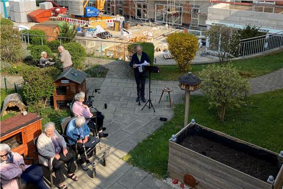 Herbert Carl musiziert vor dem Pflegewohnhaus Nehren. Im Hintergrund ist die Anbau-Baustelle zu sehen. Bild: Marc Pulla