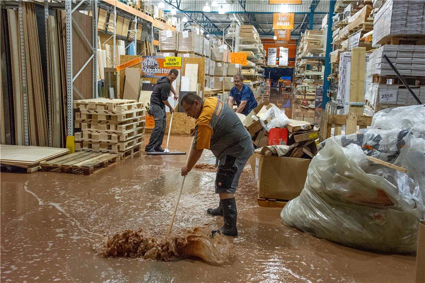 Im Hornbach-Baumarkt drückten Wasser und Schlamm in den Verkaufsraum. Mitarbeiter schoben die braune Brühe aus dem Gebäude. Bild: Klaus Franke
