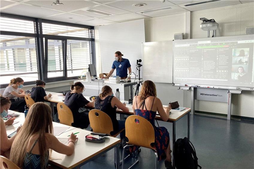 Im Hybrid-Klassenzimmer persönlich und an der Tafel anwesend: der Lehrer Nicolai Winter und sein Geschichts-Kurs. Foto: Axel Habermehl