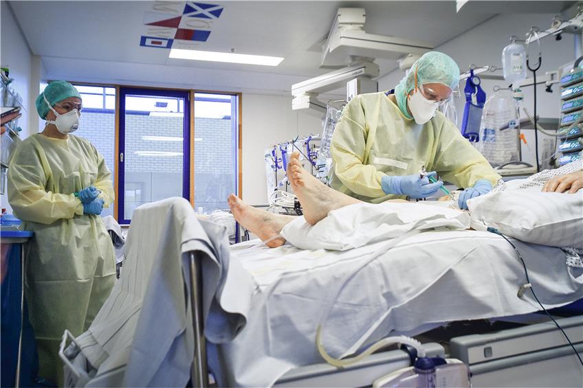 Intensivpfleger Dennis Müller (rechts) versorgt mit einer Kollegin eine 83-jährige Covid-Patientin, die maschinell beatmet werden muss. Foto: Ferdinando Iannone