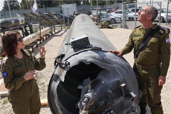 Israels Militärsprecher Daniel Hagari (rechts) und seine Stellvertreterin Masha Michelson posieren mit den Überresten einer der iranischen Raketen, die in Israel niedergegangen waren. Foto: Gil Cohen-Magen/afp