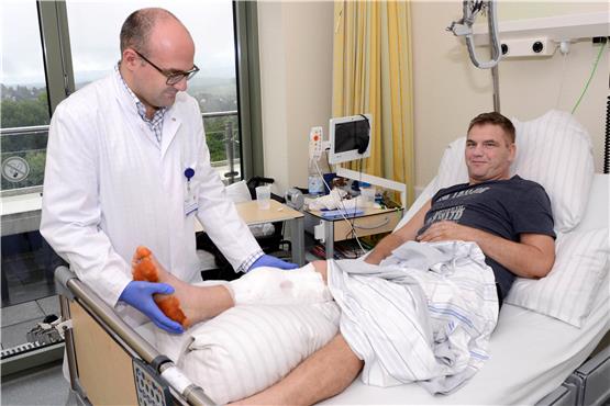 Jonas Kolbenschmid hält das Bein von Andreas Bettinger. Es war fast abgetrennt. Bild: Berufsgenossenschaftliche Unfallklinik Tübingen