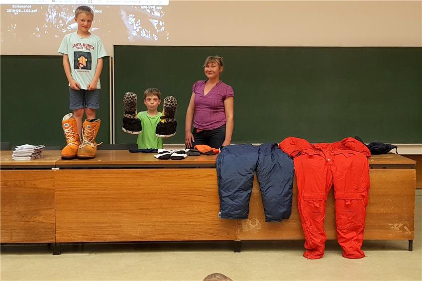 Jonathan (links) und Patrick führen vor, welche Riesenausrüstung Ilka Weikusat mit nach Grönland nimmt.Bild: Ulla Steuernagel