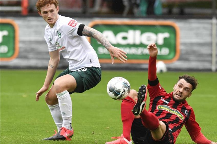 Josh Sargent von Bremen und Manuel Gulde von Freiburg (l-r.) im Zweikampf um den Ball. Foto: Thomas Kienzle/AFP-Pool/dpa