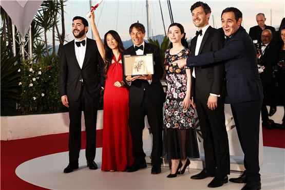 Jubel in Cannes: Sean Baker (Dritter von links), Regisseur und Drehbuchautor aus den USA, und seine Darstellerriege posieren mit der Goldenen Palme für den Film „Anora“ nach der Preisverleihung. Foto: Gao Jing/XinHua/dpa