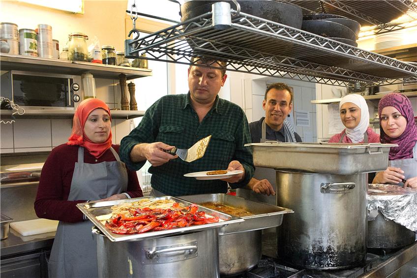 Kochen für 50 Gäste war für die Syrer kein Problem. Mona Jened (rechts) und Samar Karaf (Zweite von rechts) wollen auch künftig gerne in der Gastronomie arbeiten. Nidal Fares (Mitte) betätigte sich als Beikoch. Bild: Franke