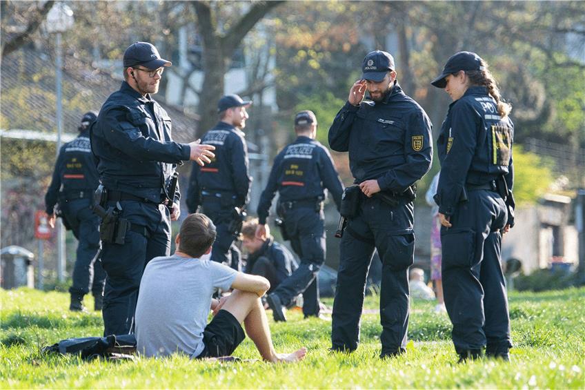 Kontrollen in Stuttgart: In einem Park sprechen Polizisten einen Mann an. Foto: Sebastian Gollnow/dpa