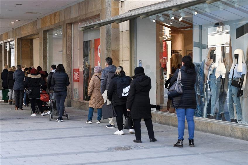 Kunden warten vor einem Modegeschäft. Der Einzelhandel warnt, dass sich diese Szene wiederholen könnte. Foto: Angelika Warmuth/dpa